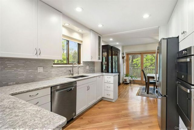 a large kitchen with stainless steel appliances granite countertop a stove a sink and a refrigerator