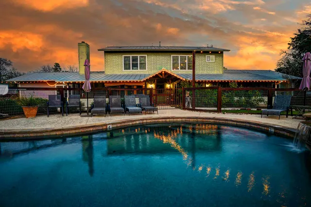 a view of house with swimming pool yard and outdoor seating