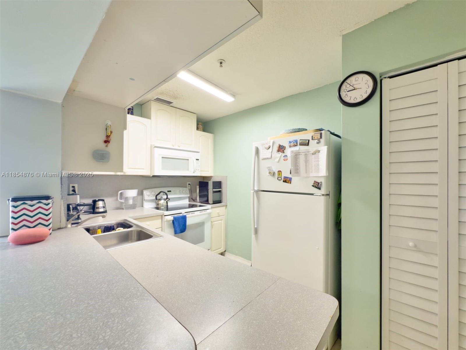 3201 West Flagler Street, Unit 209 Miami, FL 33135 - Photo 5 of 13 a kitchen with a refrigerator and a stove top oven