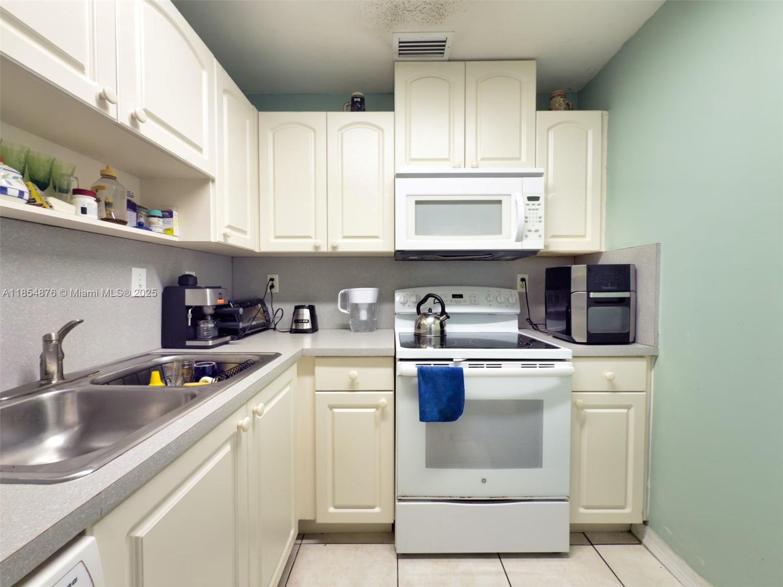 3201 West Flagler Street, Unit 209 Miami, FL 33135 - Photo 6 of 13 a kitchen with stainless steel appliances granite countertop a sink and a stove
