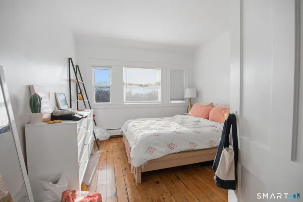 a bedroom with a bed next to a window with chair