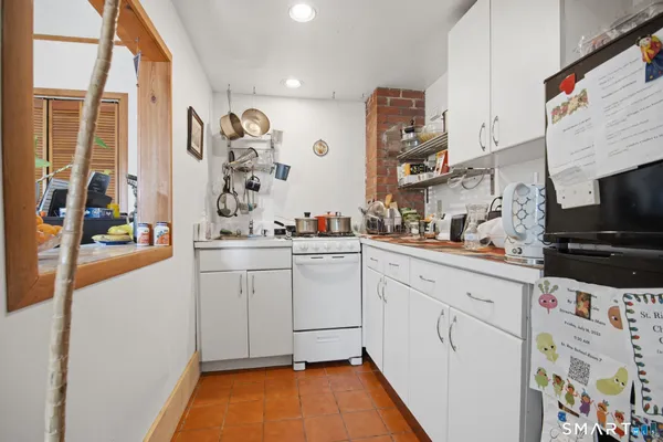 a kitchen with white cabinets and window