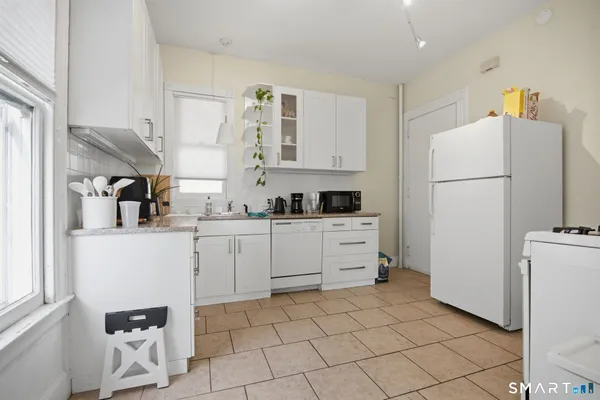 a kitchen with a refrigerator a stove top oven and cabinets