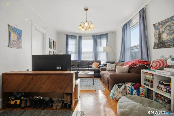 a living room with furniture a window and a chandelier