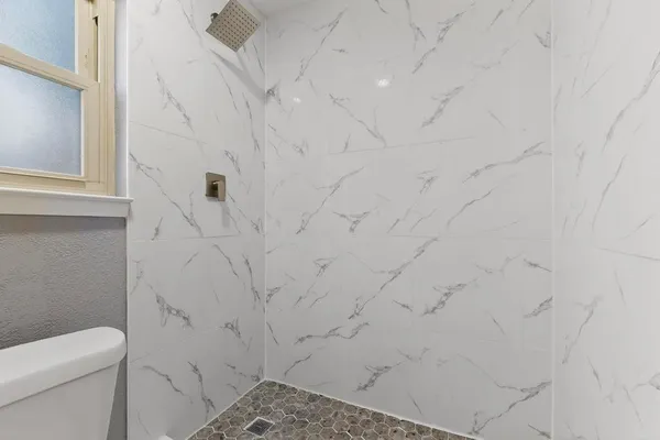 a bathroom with a toilet and a shower