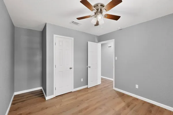 a view of an empty room with wooden floor