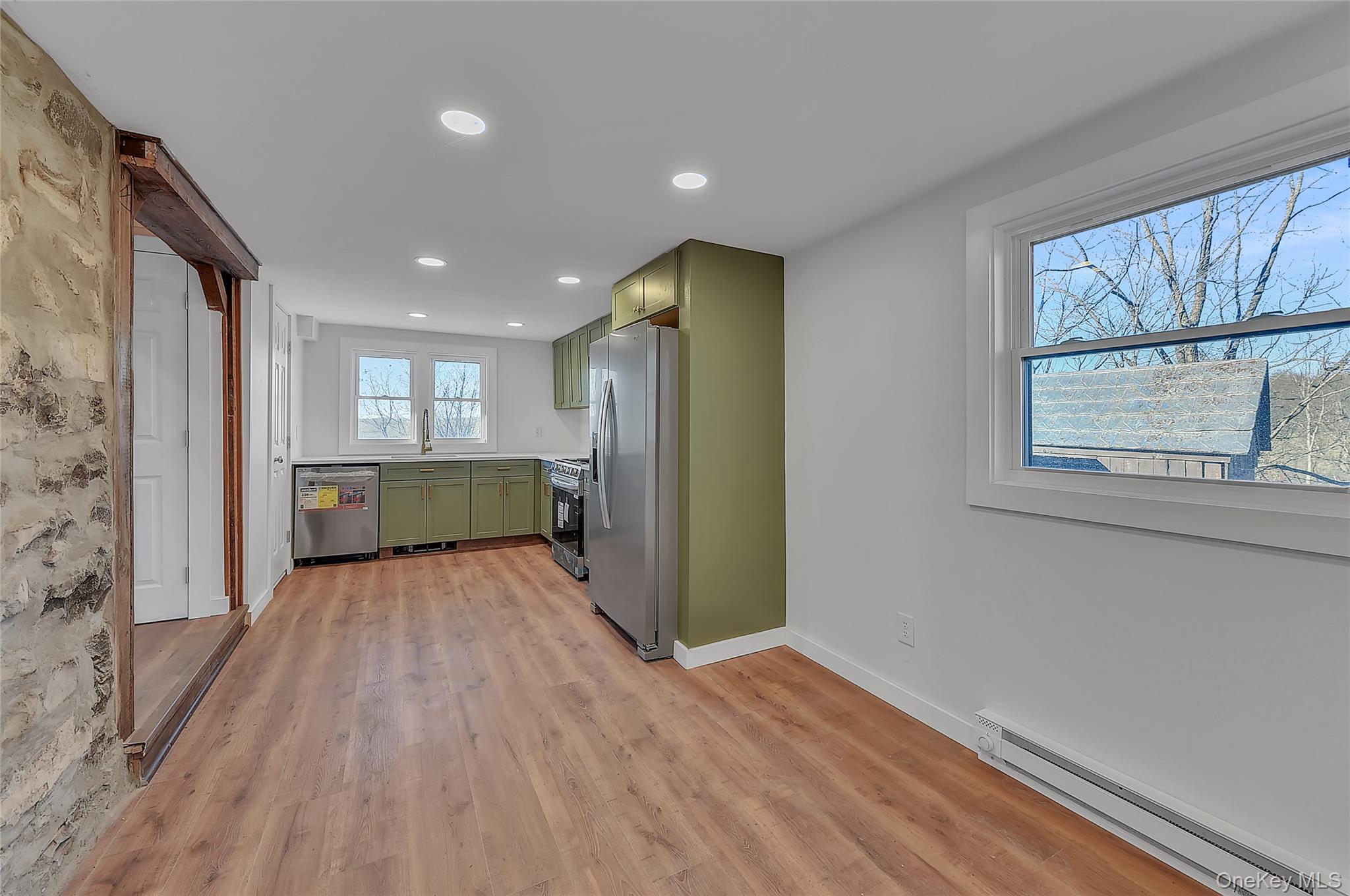 67 Jacobs Road Westtown, NY 10998 - Photo 8 of 36 Kitchen with green cabinets, baseboard heating, stainless steel appliances, light countertops, and light wood finished floors