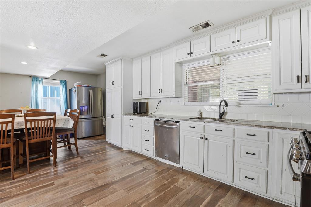 500 West Rucker Street Granbury, TX 76048 - Photo 11 of 35 a kitchen with sink cabinets and wooden floor