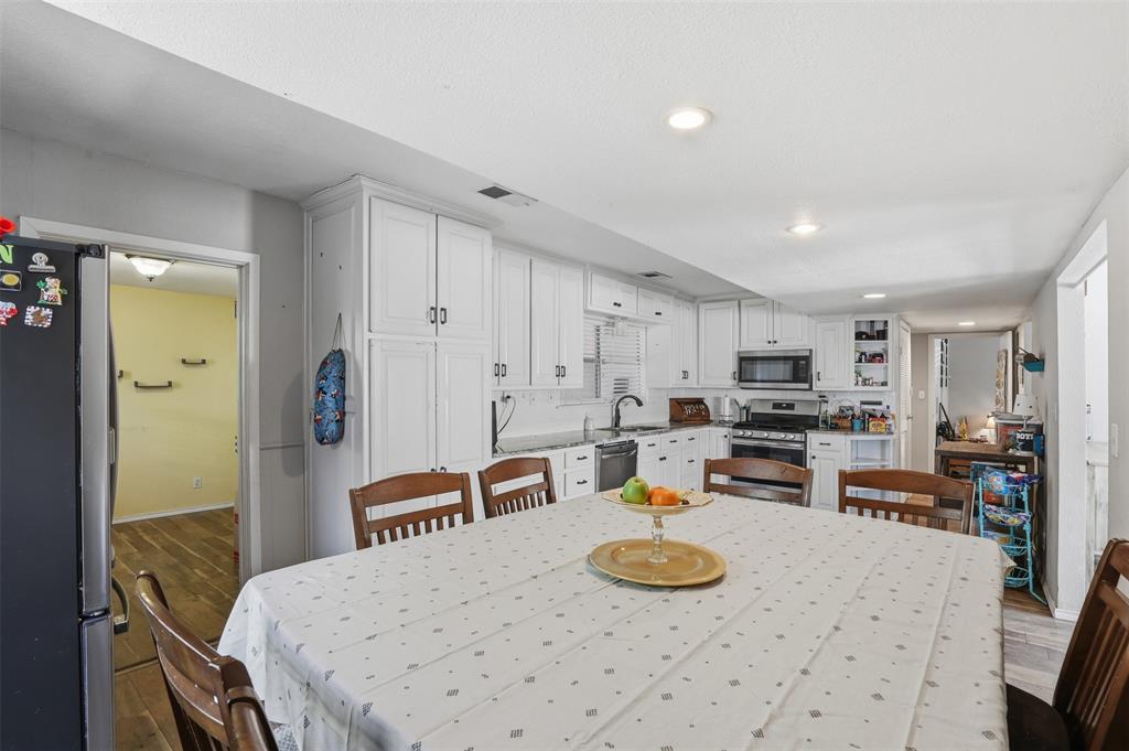 500 West Rucker Street Granbury, TX 76048 - Photo 14 of 35 a kitchen with stainless steel appliances kitchen island granite countertop a sink and cabinets