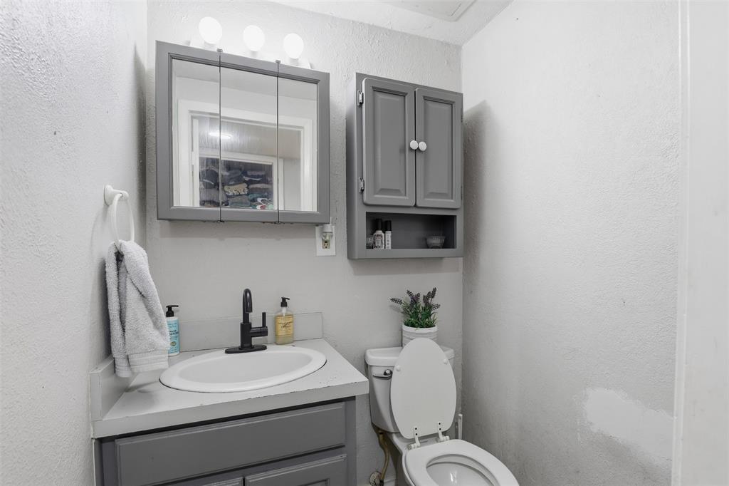 500 West Rucker Street Granbury, TX 76048 - Photo 16 of 35 a bathroom with a toilet a sink and mirror