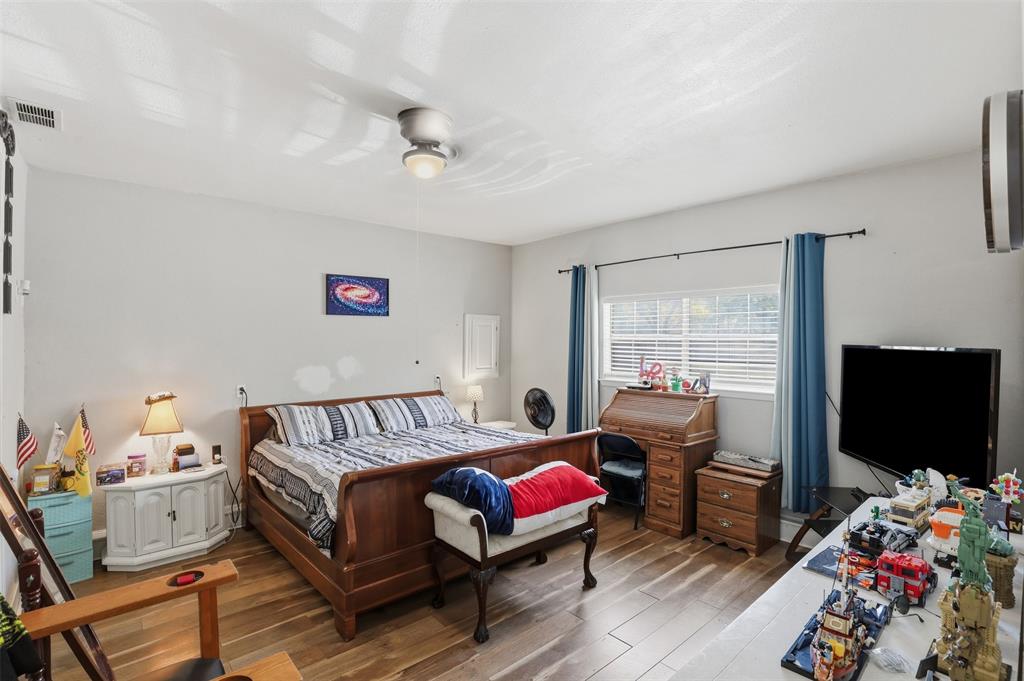 500 West Rucker Street Granbury, TX 76048 - Photo 20 of 35 a bedroom with furniture and a flat screen tv