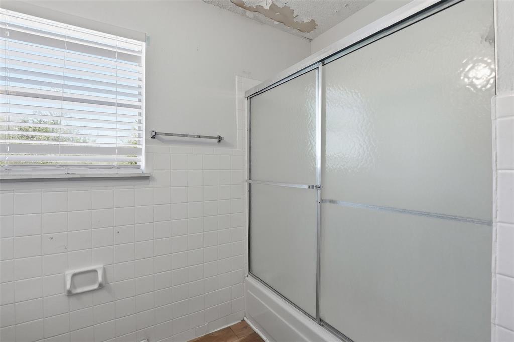 500 West Rucker Street Granbury, TX 76048 - Photo 25 of 35 a bathroom with a glass shower door