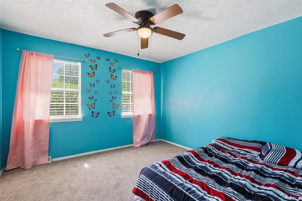 500 West Rucker Street Granbury, TX 76048 - Photo 31 of 35 a bedroom with a bed and a chandelier