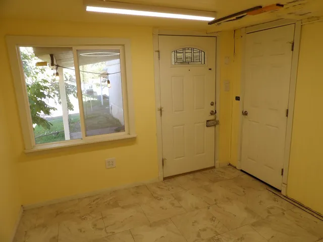 a view of an empty room with a fireplace and a window