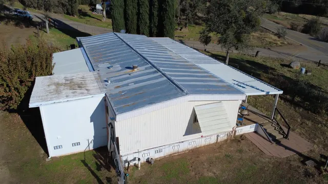a view of a house with backyard and trees