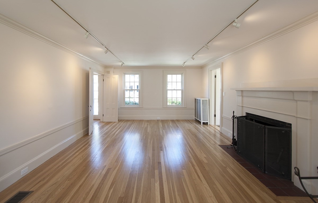 153 Watson Road Belmont, MA 02478 - Photo 3 of 20 an empty room with wooden floor and fireplace