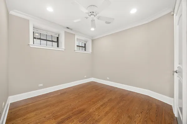 a view of empty room with wooden floor