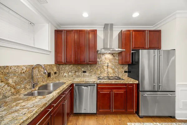 a kitchen with stainless steel appliances granite countertop a refrigerator and a sink