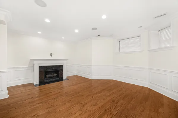 a view of empty room with wooden floor and fireplace