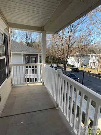 a view of a porch with wooden floor and floor to ceiling window