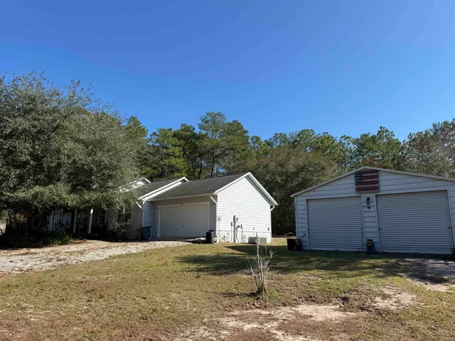 a view of a house with backyard and trees