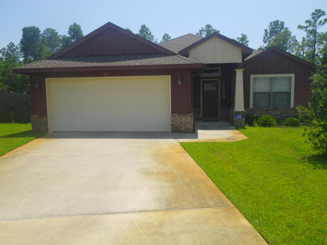 9273 Sundance Court Navarre, FL 32566 - Photo 1 of 33 a front view of a house with garden