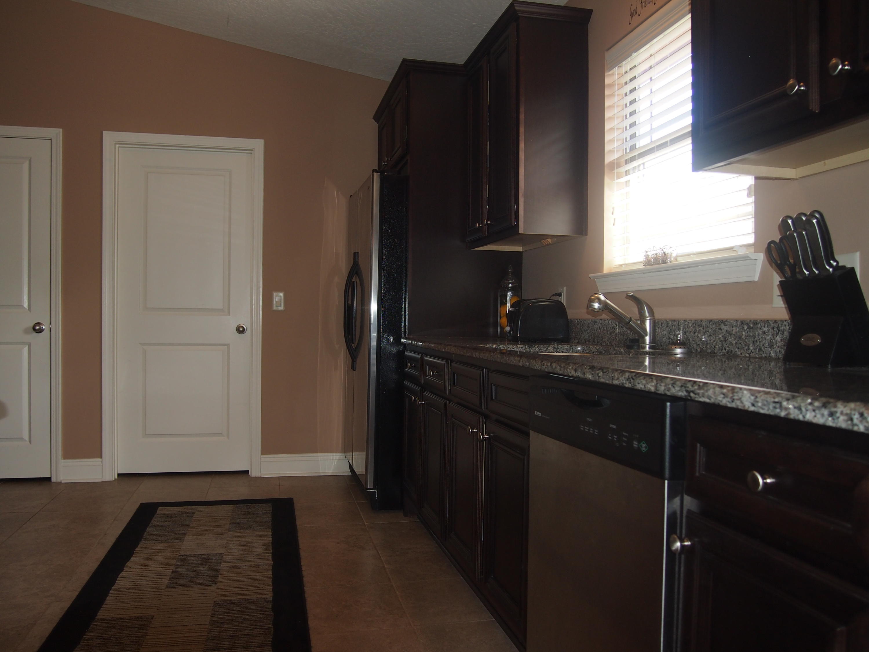 9273 Sundance Court Navarre, FL 32566 - Photo 11 of 33 a kitchen with granite countertop a sink a window and cabinets