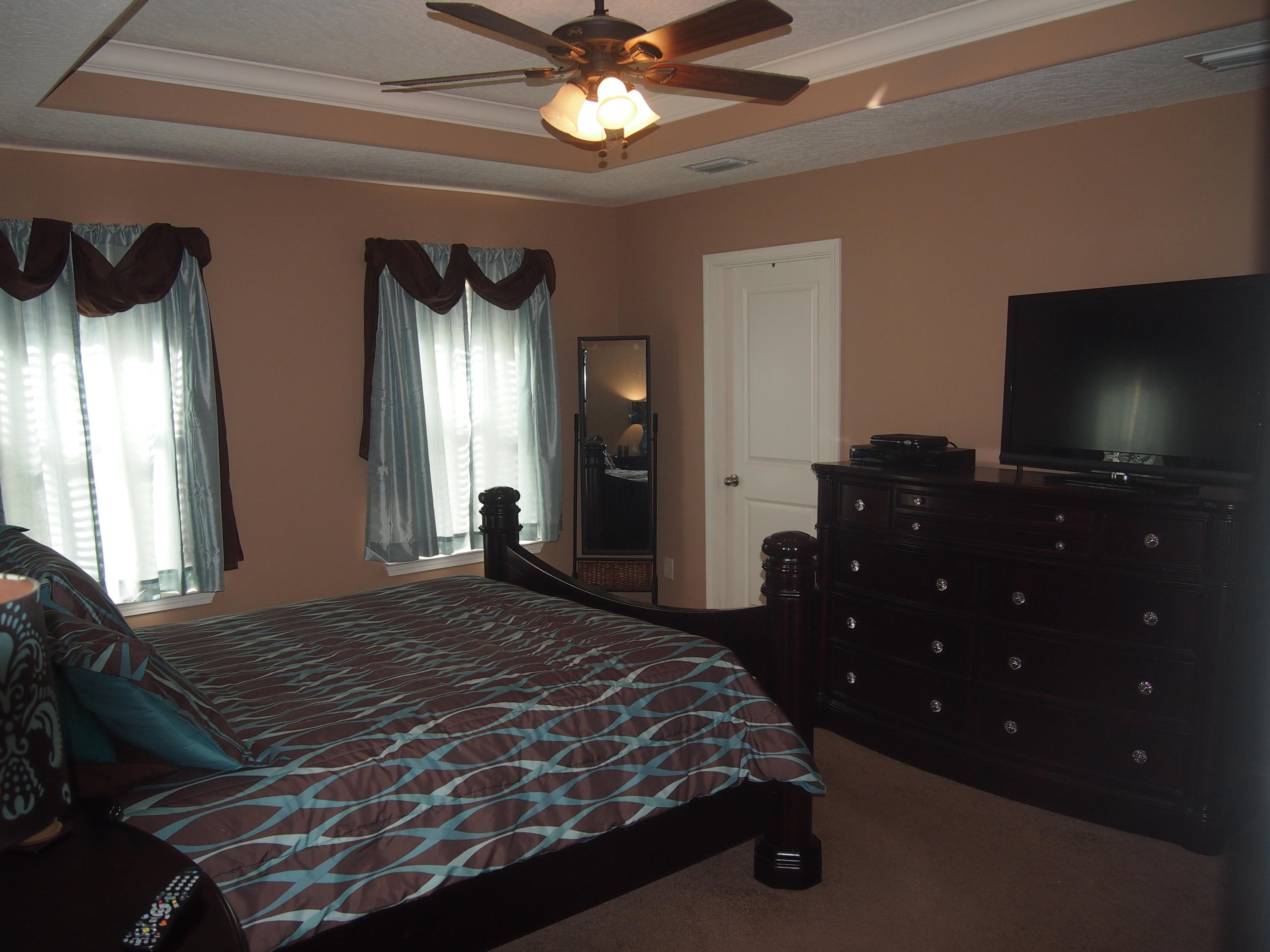 9273 Sundance Court Navarre, FL 32566 - Photo 17 of 33 a bedroom with a bed and a flat tv screen on dresser
