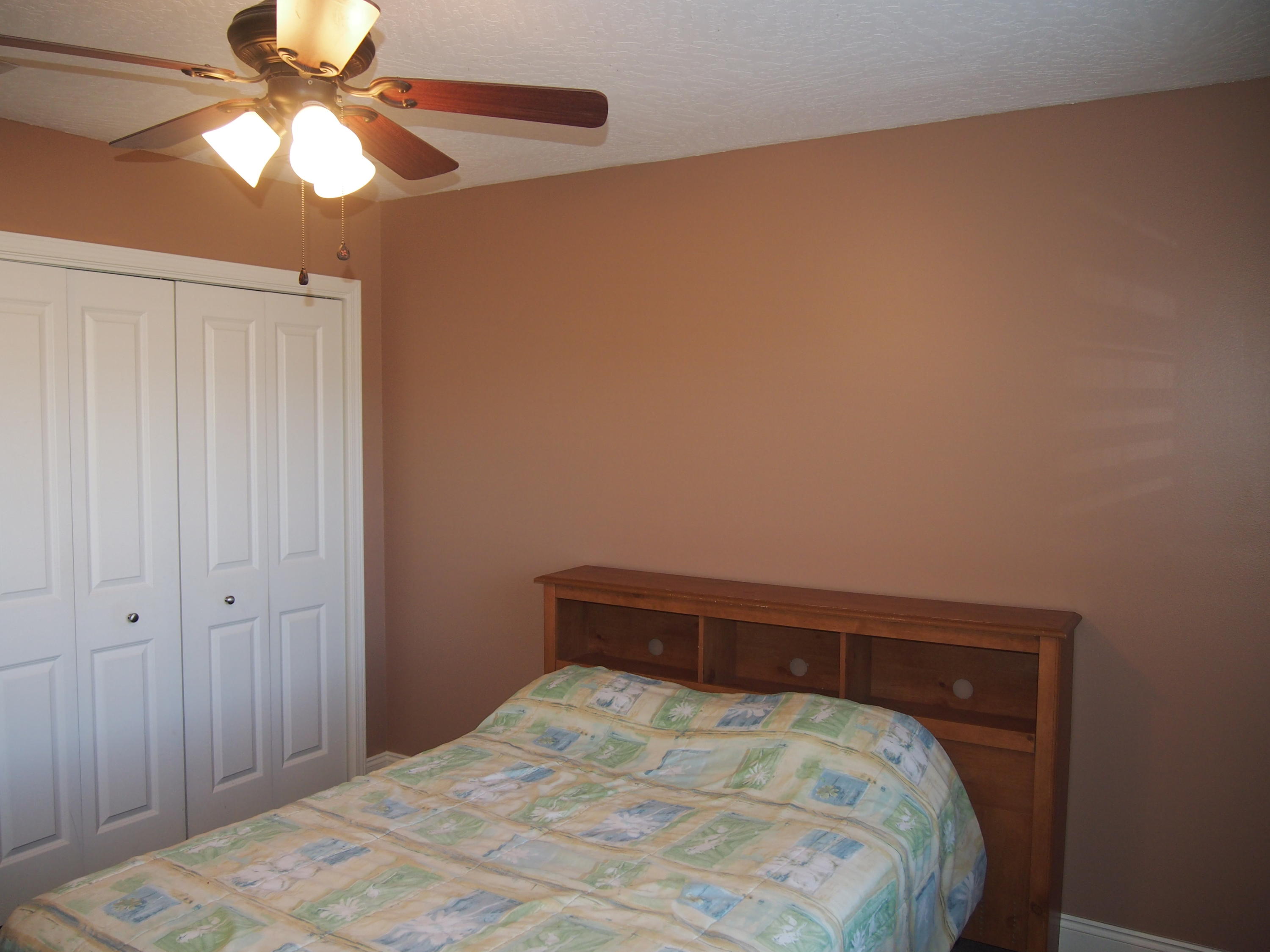 9273 Sundance Court Navarre, FL 32566 - Photo 21 of 33 a bedroom with a bed and a chandelier fan