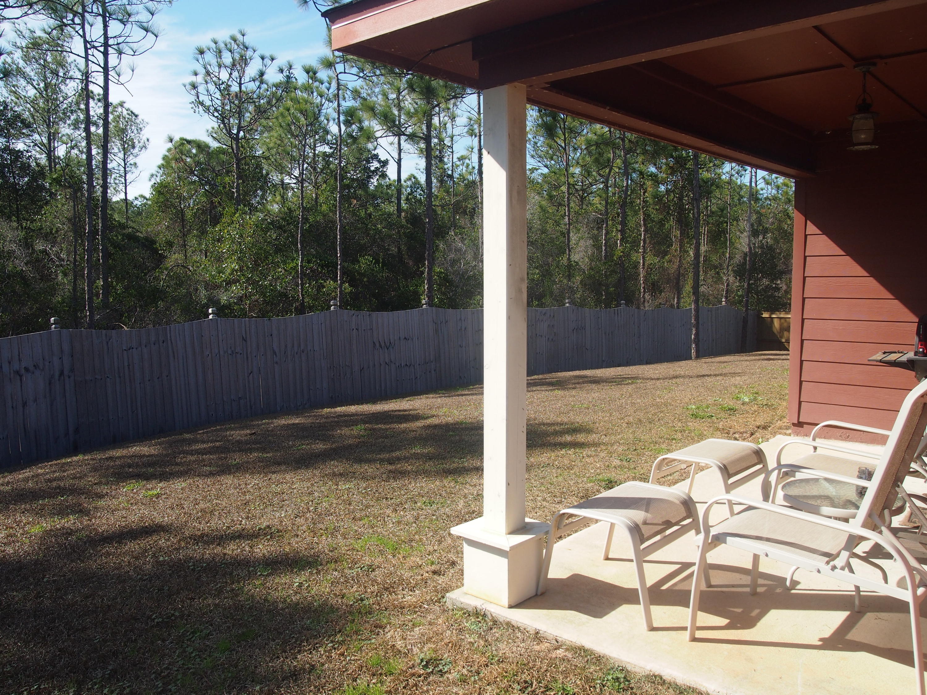 9273 Sundance Court Navarre, FL 32566 - Photo 25 of 33 a view of a patio with table and chairs with wooden floor and fence