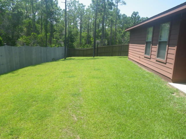 9273 Sundance Court Navarre, FL 32566 - Photo 26 of 33 a view of a backyard with a small cabin