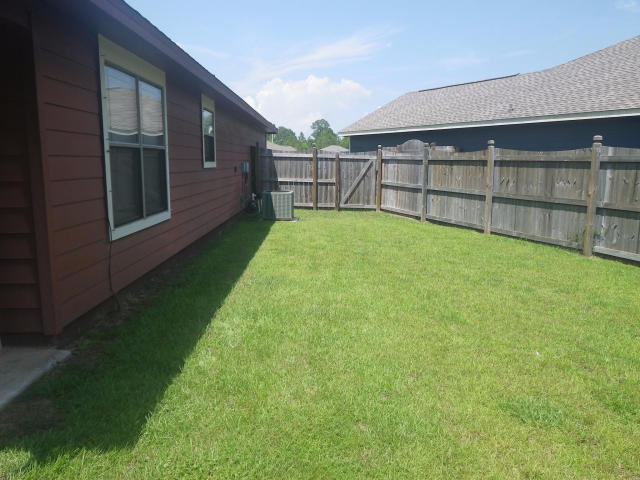 9273 Sundance Court Navarre, FL 32566 - Photo 27 of 33 a view of a backyard with a garden