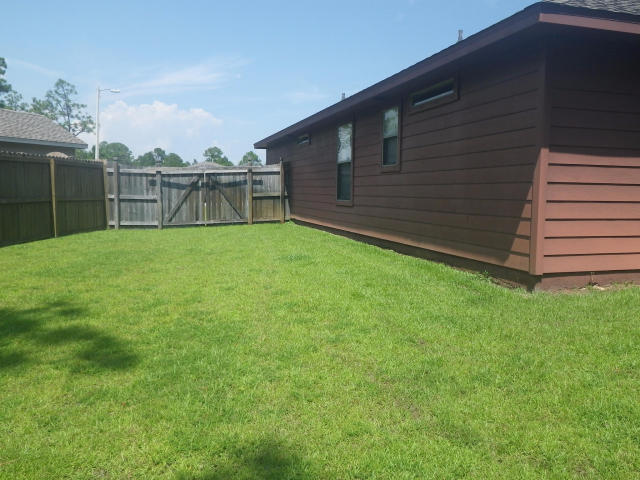 9273 Sundance Court Navarre, FL 32566 - Photo 28 of 33 a backyard of a house with lots of green space