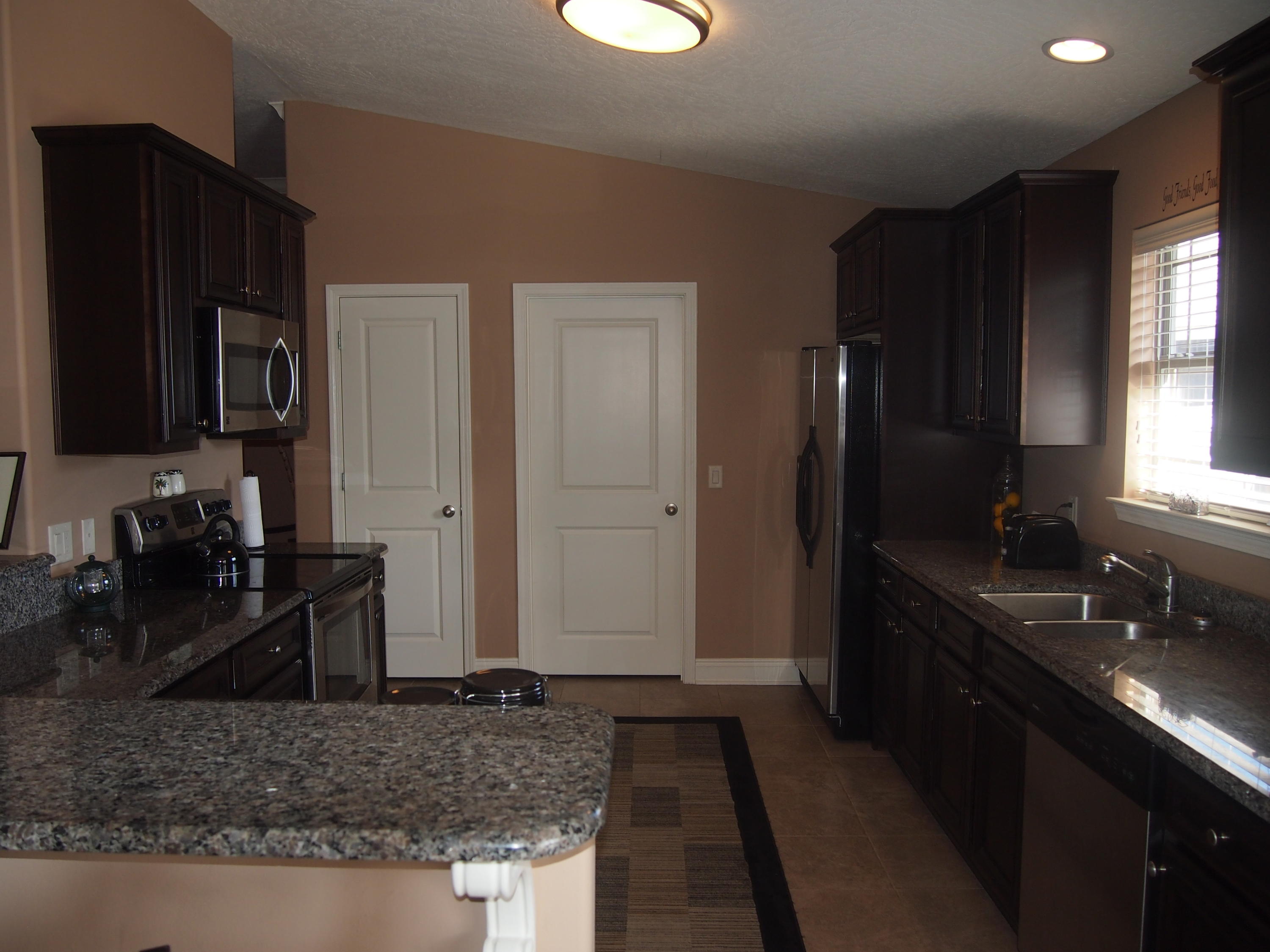 9273 Sundance Court Navarre, FL 32566 - Photo 8 of 33 a kitchen with granite countertop a refrigerator stove and sink