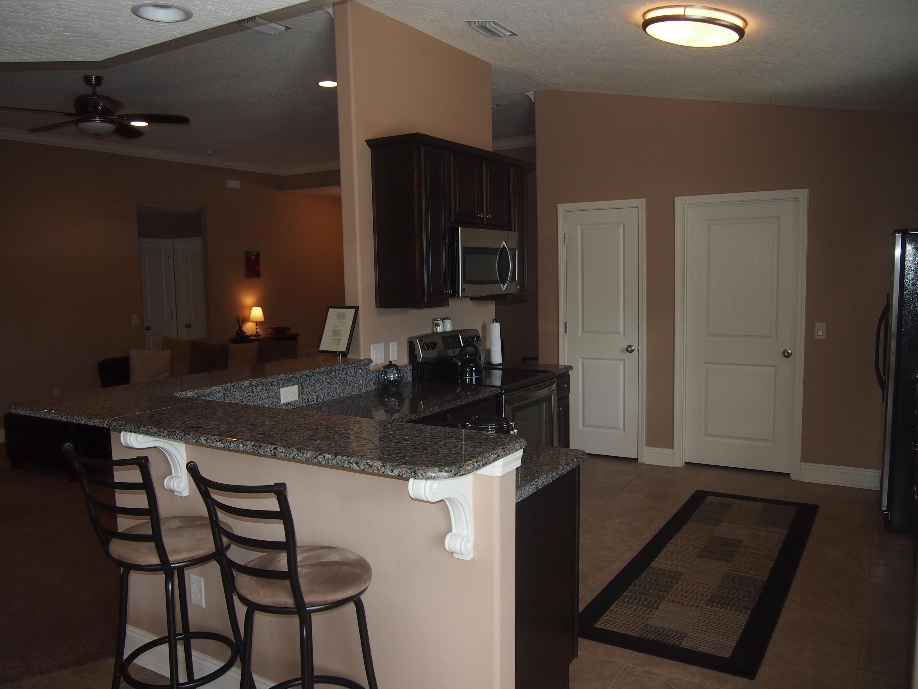 9273 Sundance Court Navarre, FL 32566 - Photo 9 of 33 a kitchen with a sink cabinets and wooden floor