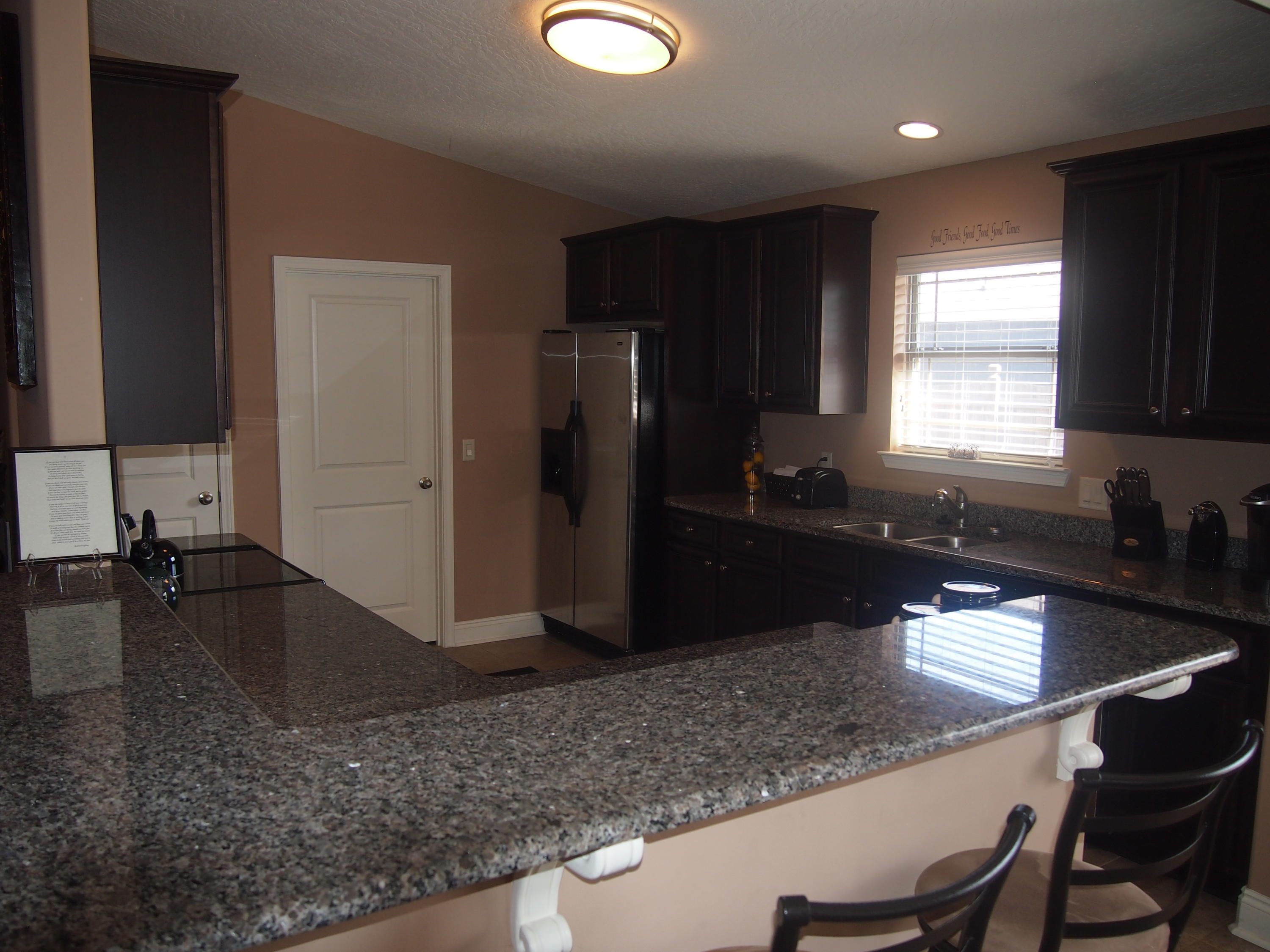 9273 Sundance Court Navarre, FL 32566 - Photo 10 of 33 a kitchen with granite countertop a sink refrigerator and cabinets