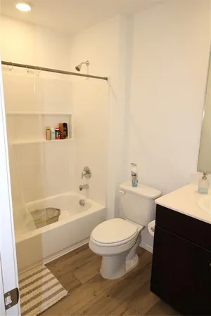 a white toilet sitting next to a bath tub