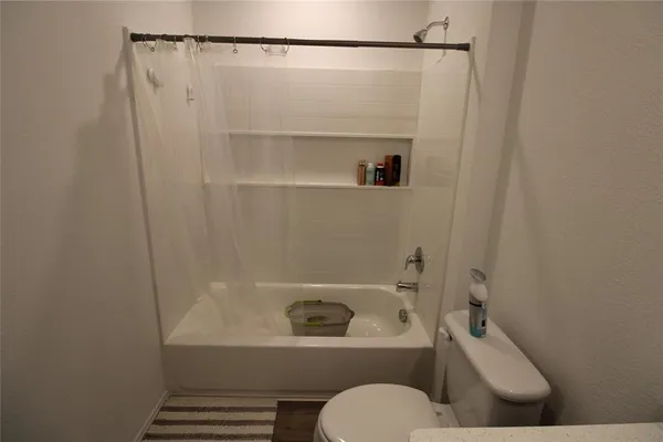 a bathroom with a toilet and a shower