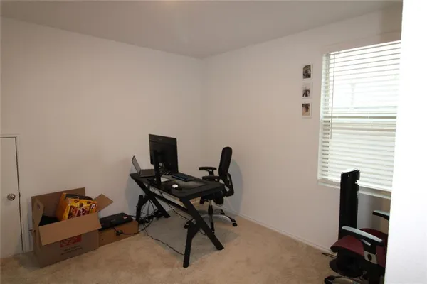 a view of a workspace with furniture and a window