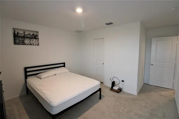 a bed sitting in a bedroom next to a window