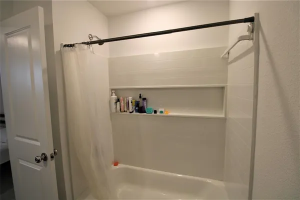 a bathroom with a shower and a bath tub