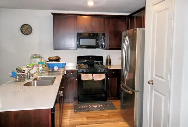 a kitchen with stainless steel appliances a refrigerator sink and microwave