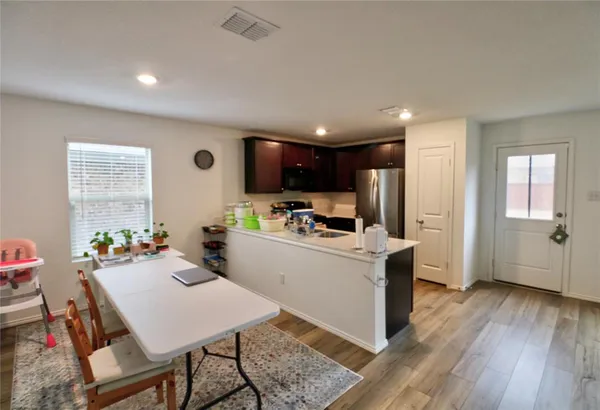 a living room with stainless steel appliances kitchen island granite countertop furniture wooden floor and a window