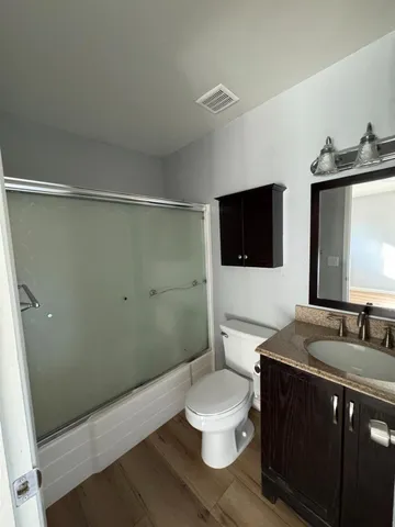 a bathroom with a sink a toilet a mirror and shower