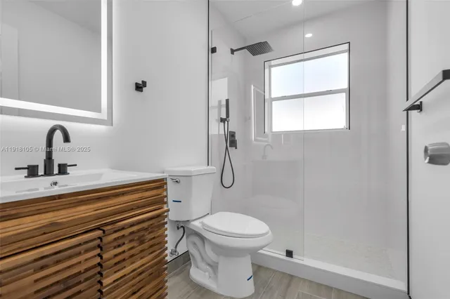 a bathroom with a sink a toilet and shower