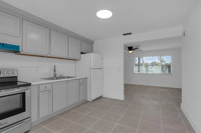 a kitchen with granite countertop white cabinets and stainless steel appliances