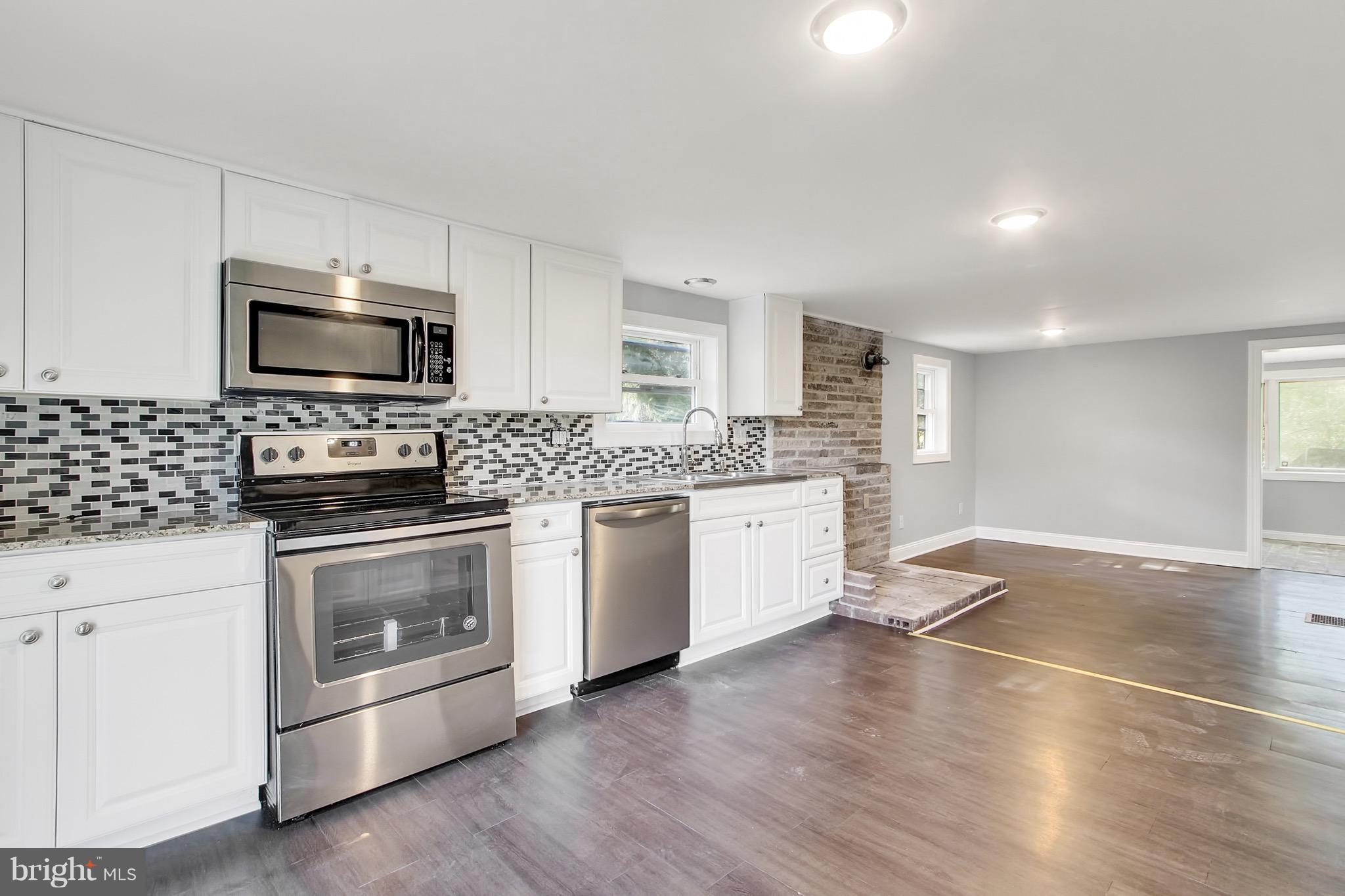 1807 Jug Road Dover, PA 17315 - Photo 6 of 27 a kitchen with granite countertop a stove a sink and a microwave