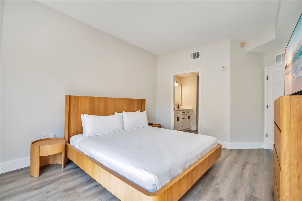 8601 Worldquest Boulevard, Unit 3108 Orlando, FL 32821 - Photo 12 of 24 a bedroom with a bed and a chair with wooden floor