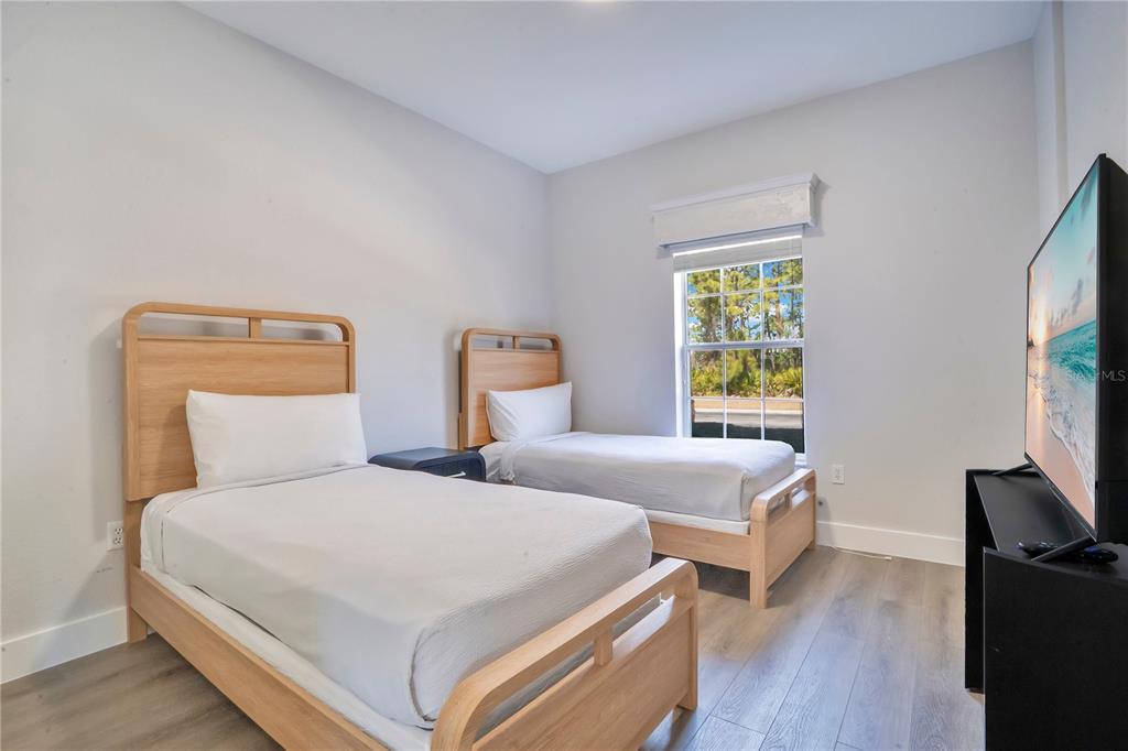 8601 Worldquest Boulevard, Unit 3108 Orlando, FL 32821 - Photo 16 of 24 a bedroom with two beds and a flat screen tv
