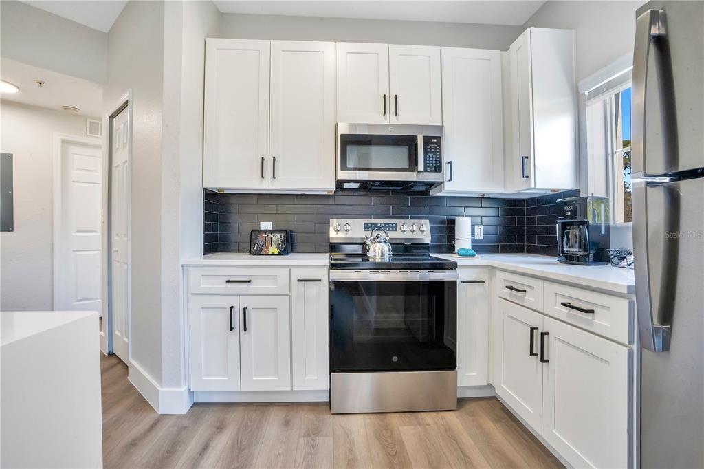 8601 Worldquest Boulevard, Unit 3108 Orlando, FL 32821 - Photo 4 of 24 a kitchen with stainless steel appliances granite countertop a stove a sink and a refrigerator